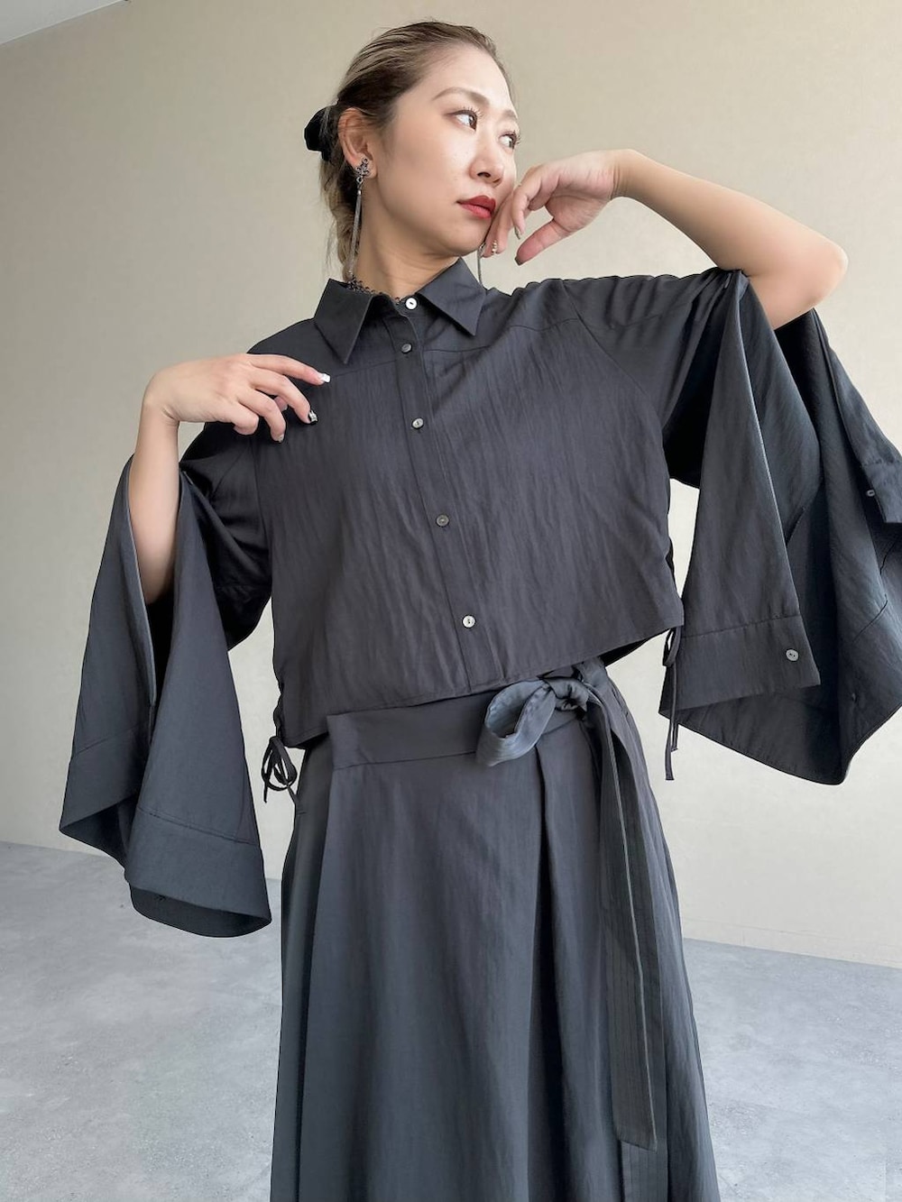 ブラック系のブーツ、グレー系のスカート、グレー系のシャツ/ブラウスを着用したレディースの秋コーディネートの3枚目の写真