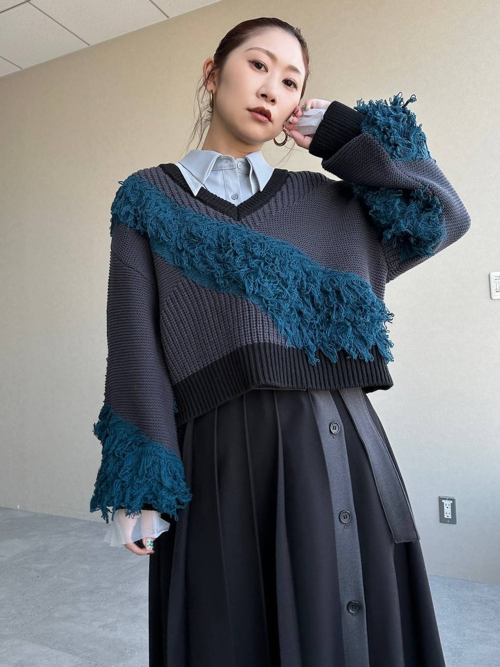 ブラック系のスカート、ブルー系のニット/セーターを着用したレディースの冬コーディネートの4枚目の写真