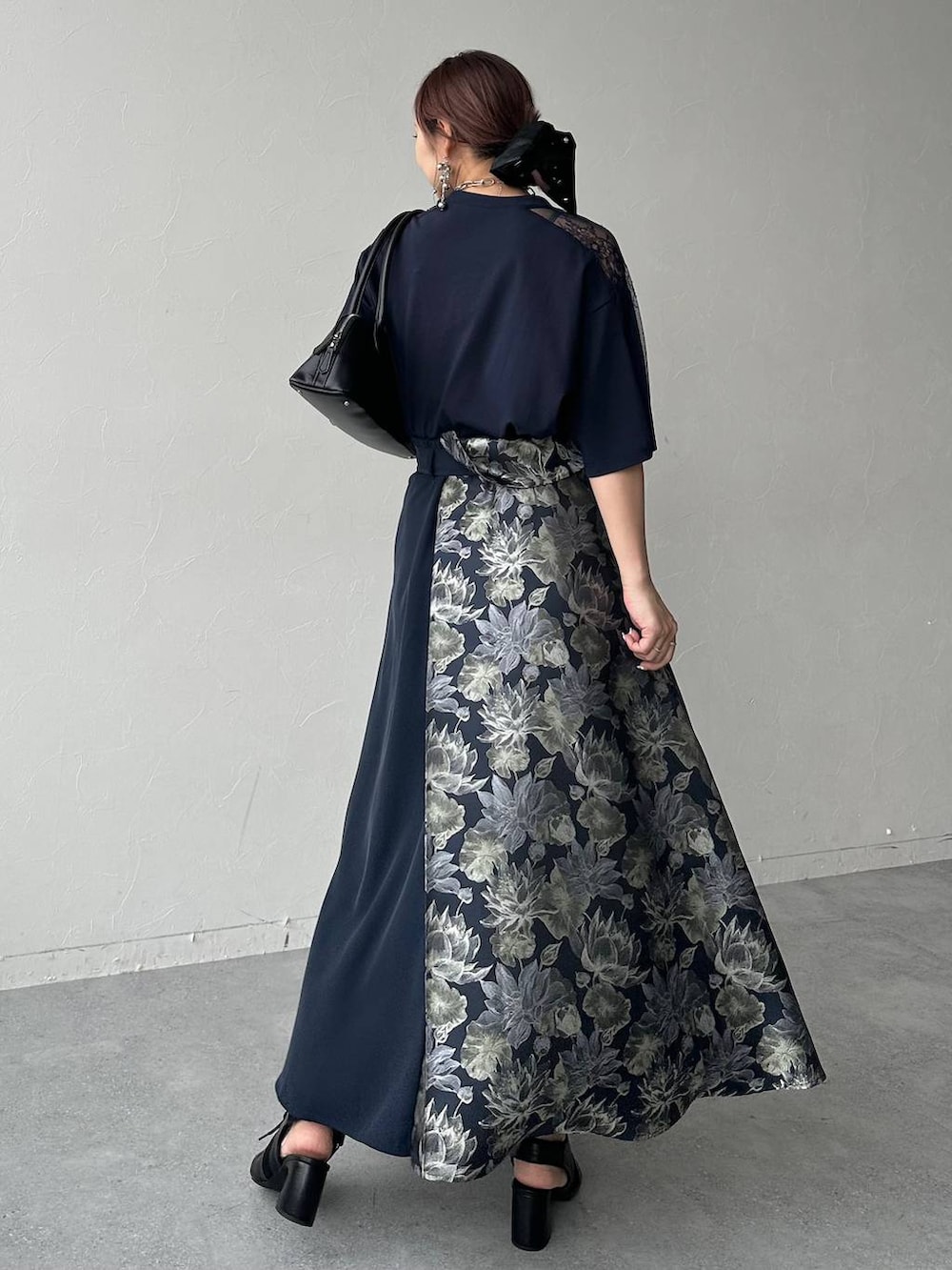 ブラック系のサンダル、ブラック系のハンドバッグ、ブルー系のスカートを着用したレディースの春コーディネートの3枚目の写真