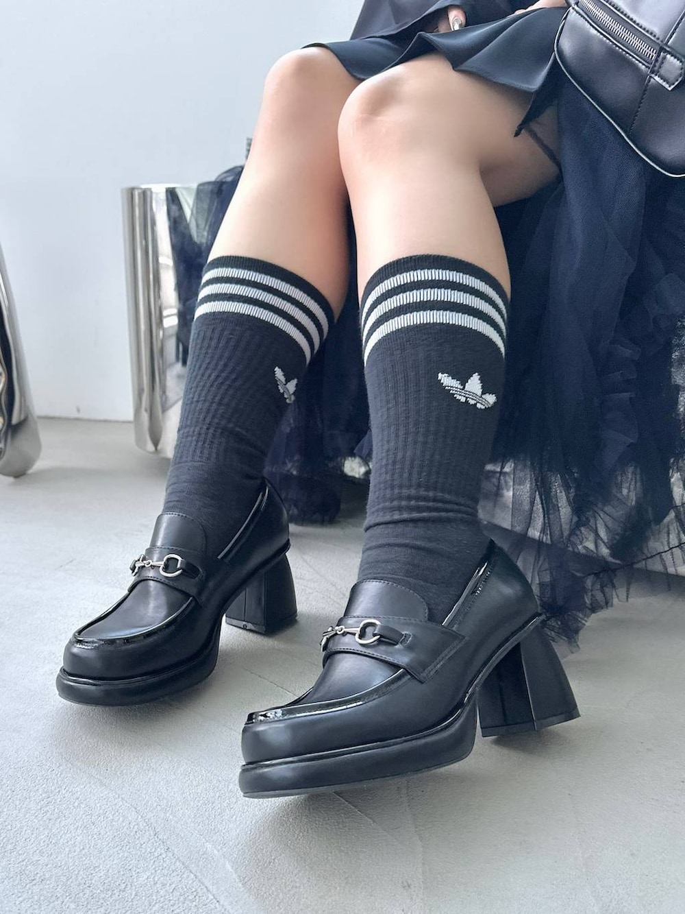 ブラック系のボストンバッグ、ブラック系のシャツ/ブラウス、ブラック系のローファーを着用したレディースの夏コーディネートの8枚目の写真