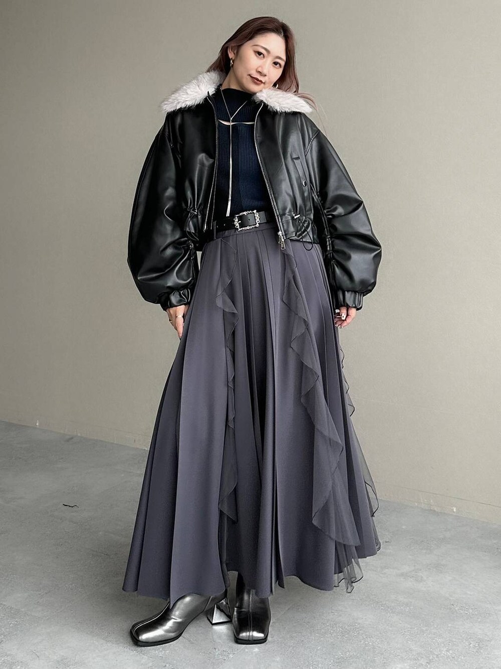 シルバー系のブーツ、ブラック系のニット/セーター、ブラック系のベルトを着用したレディースの秋コーディネートの8枚目の写真