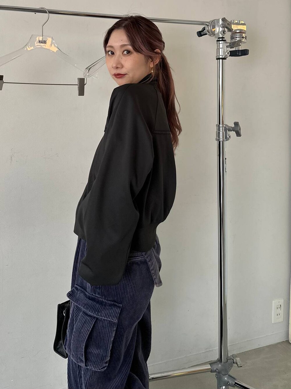 ブラック系のショルダーバッグ、ブルー系のパーカー、ブルー系のカーゴパンツを着用したレディースの秋コーディネートの5枚目の写真