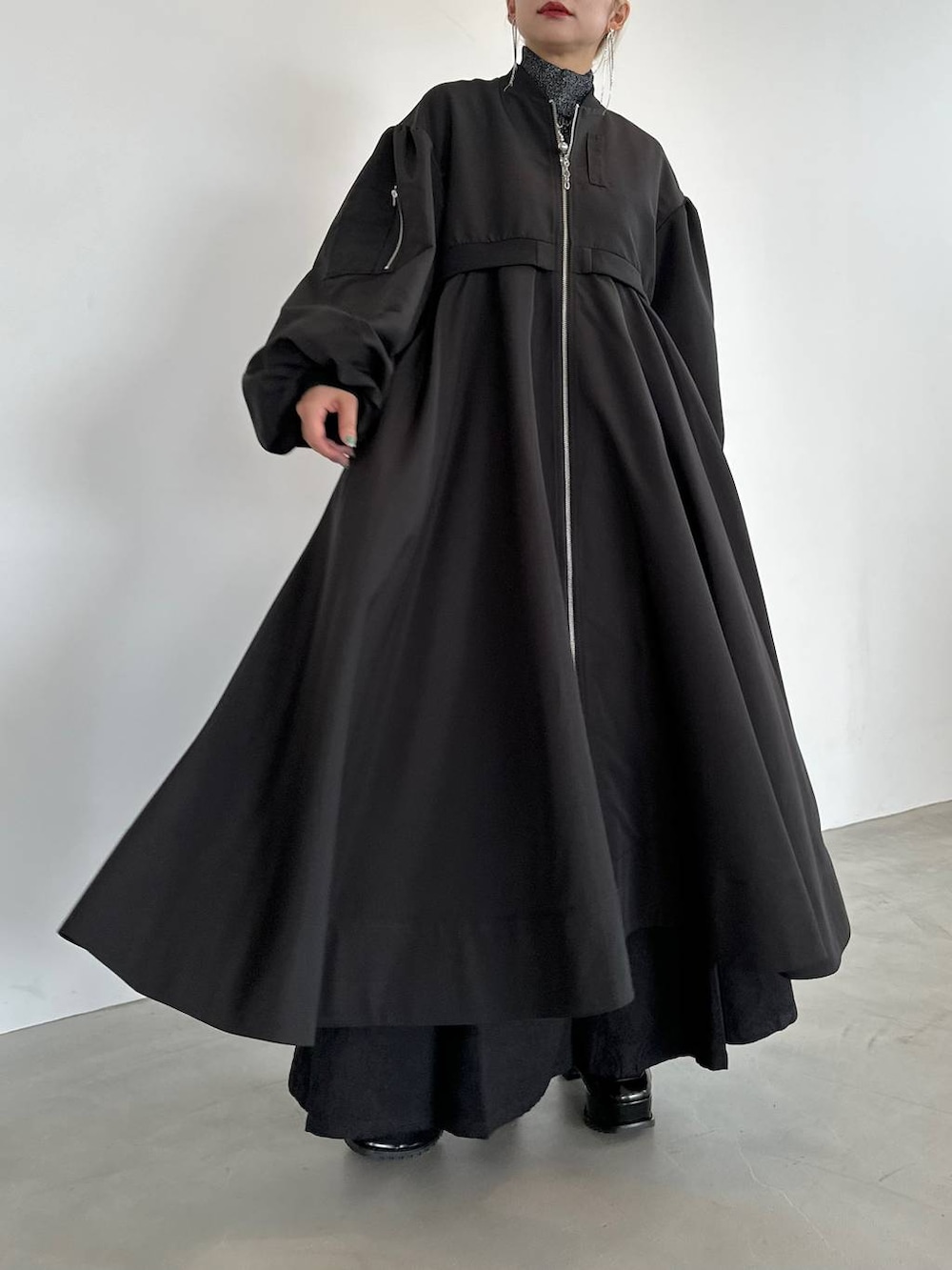 ブラック系のニット/セーター、ブラック系のブーツ、ブラック系のブルゾンを着用したレディースの秋コーディネートの7枚目の写真