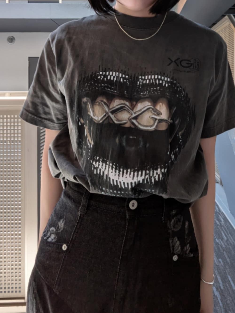 ブラック系のデニムパンツを着用したレディースの春コーディネートの2枚目の写真