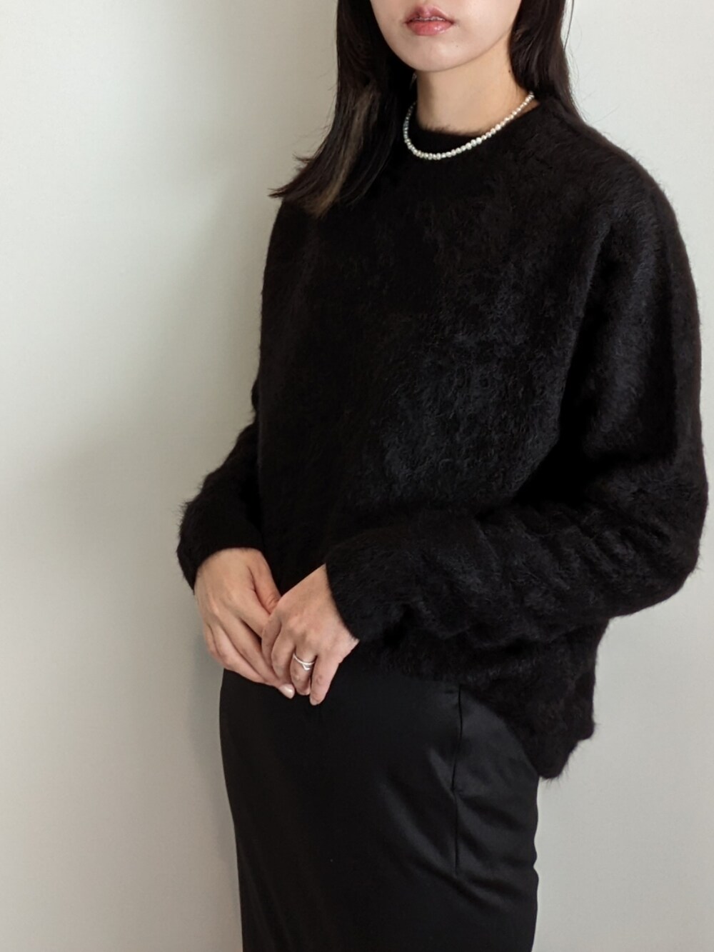 ブラック系のニット/セーター、ブラック系のスカートを着用したレディースの冬コーディネートの2枚目の写真