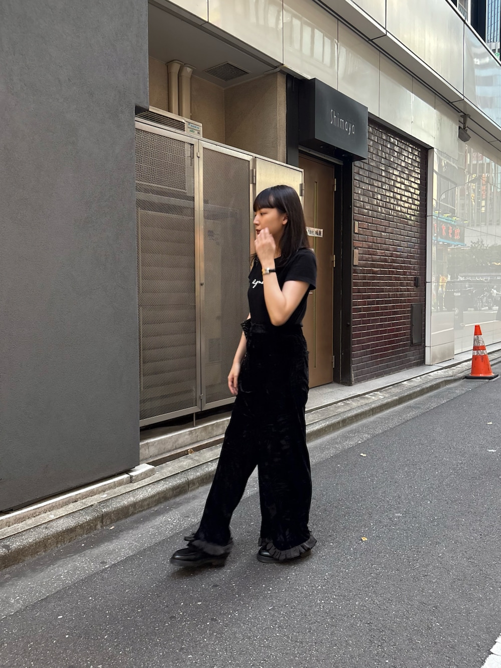 ブラック系のTシャツ/カットソー、ブラック系のローファー、ブラック系のパンツを着用したレディースの秋コーディネートの4枚目の写真