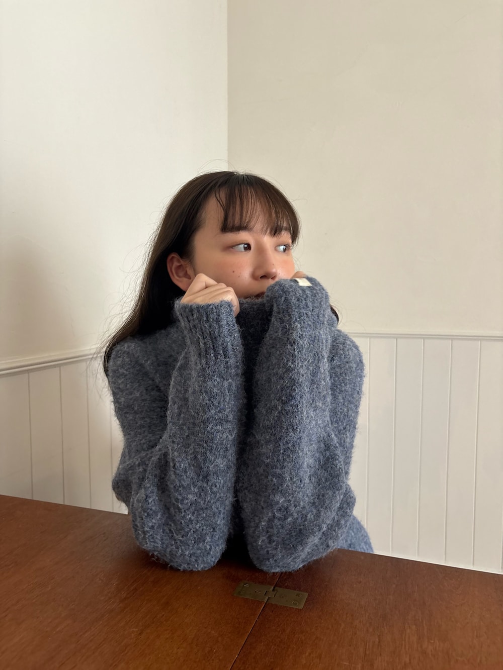 ブルー系のニット/セーターを着用したレディースの秋コーディネートの5枚目の写真