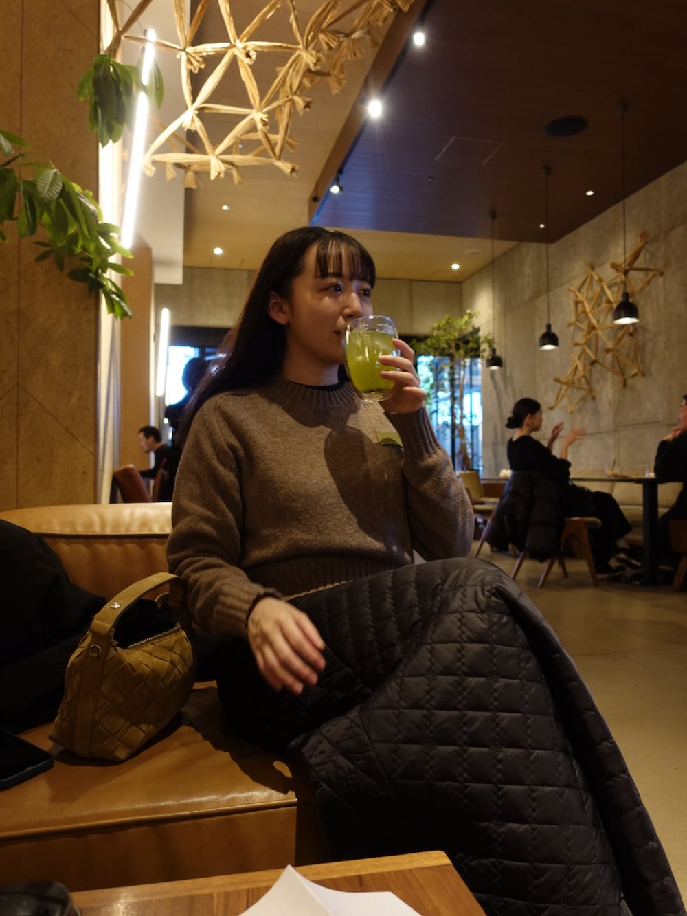 ベージュ系のニット/セーター、ブラック系のスカート、ベージュ系のスニーカーを着用したレディースの冬コーディネートの3枚目の写真