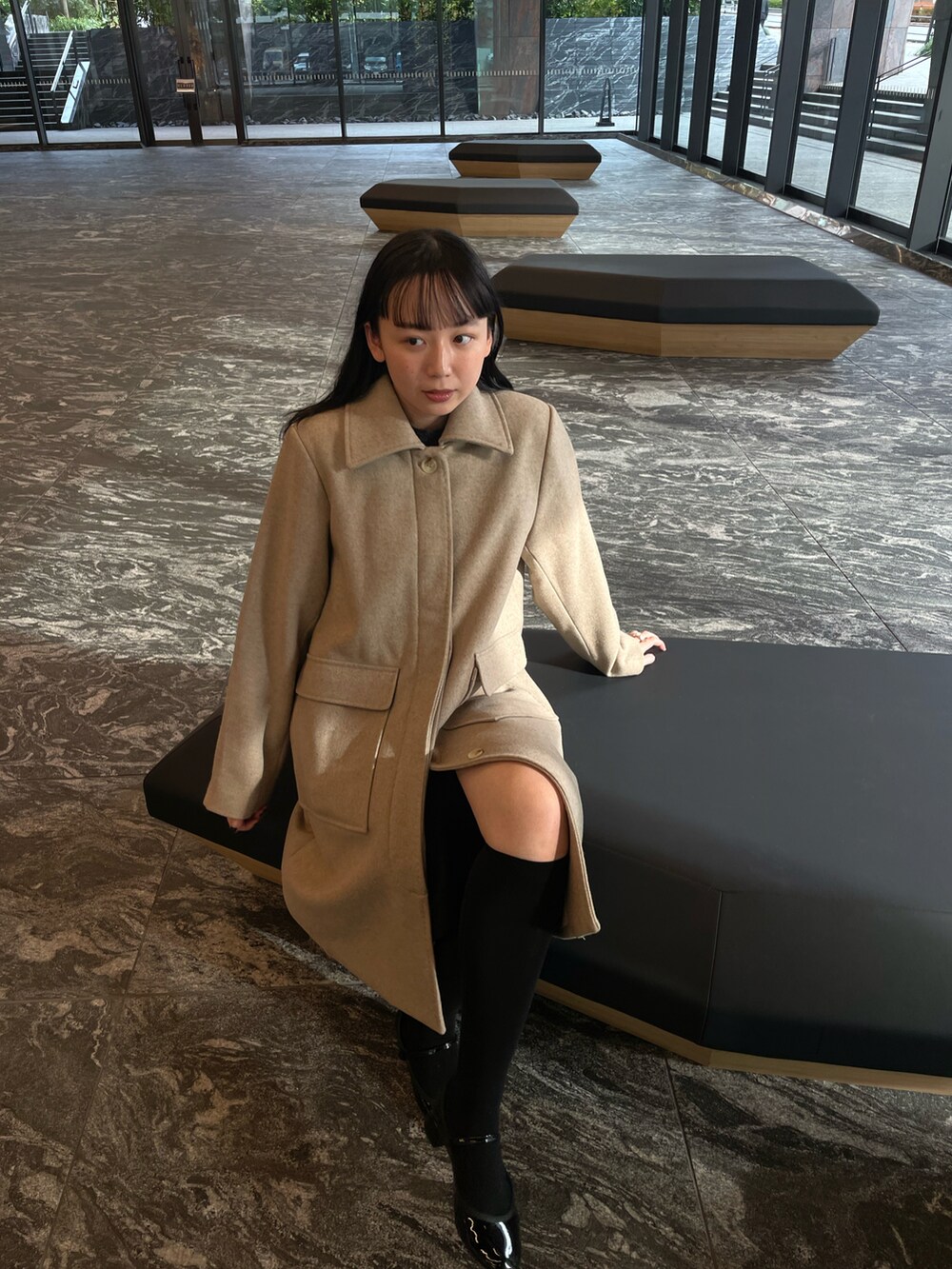 ベージュ系のジャケット/アウター、ブラック系のトップス、ブラック系のスカートを着用したレディースの冬コーディネートの2枚目の写真