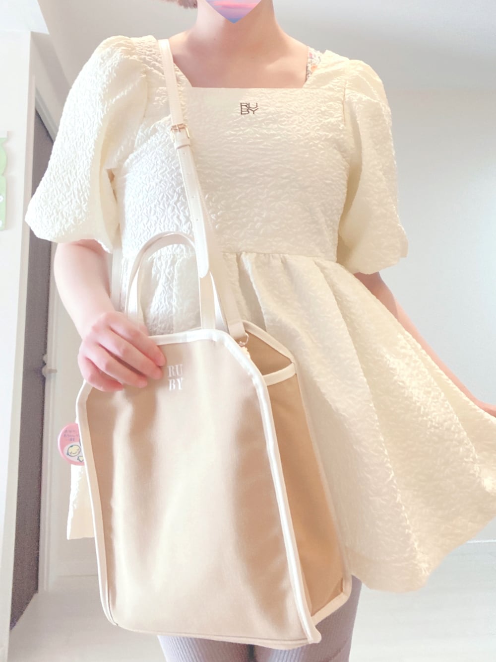 ベージュ系のショルダーバッグ、ホワイト系のトップス、ブラウン系のパンプスを着用したレディースの秋コーディネートの2枚目の写真