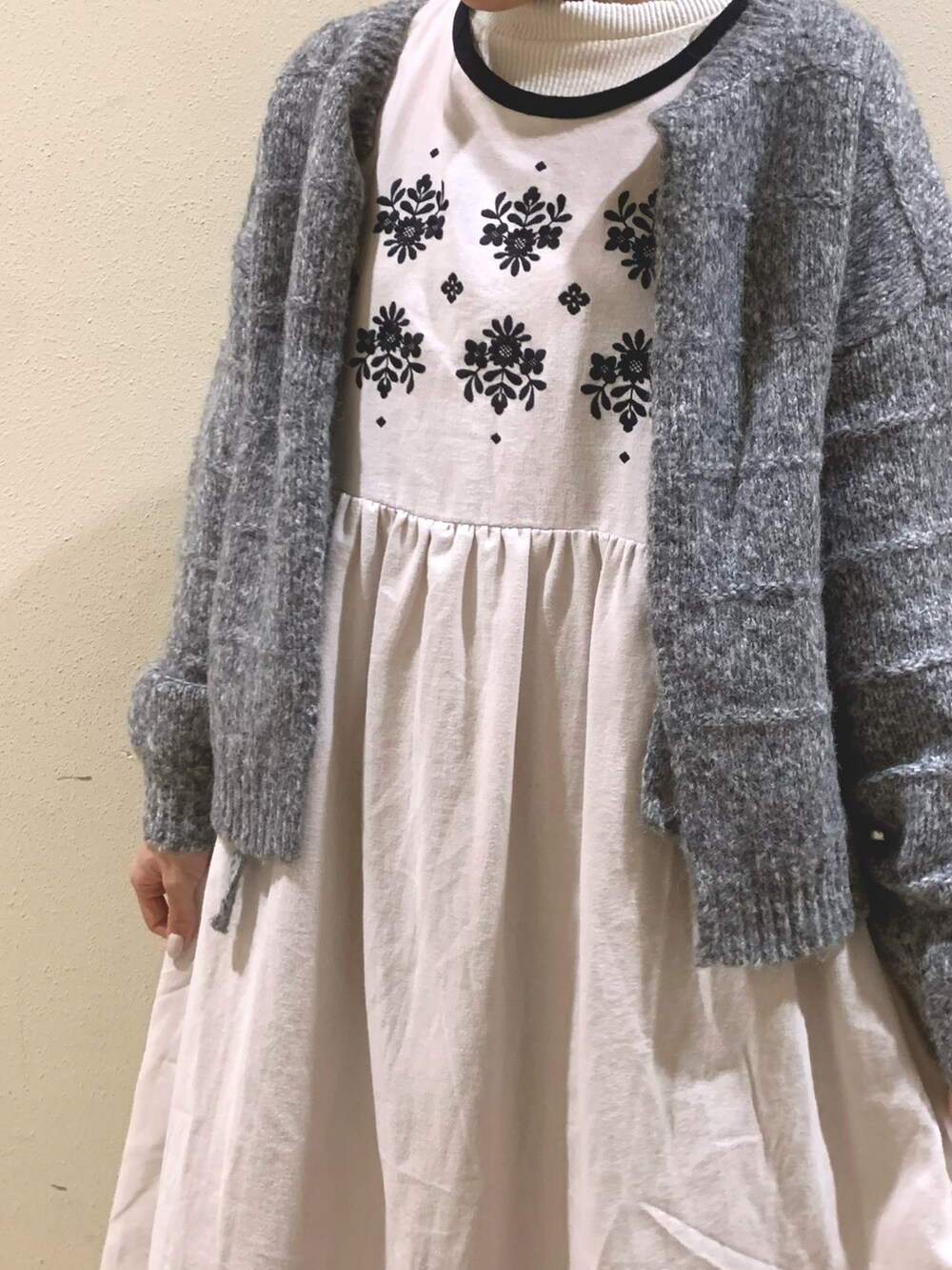 ホワイト系のワンピース、グレー系のカーディガン/ボレロを着用したレディースの冬コーディネートの2枚目の写真