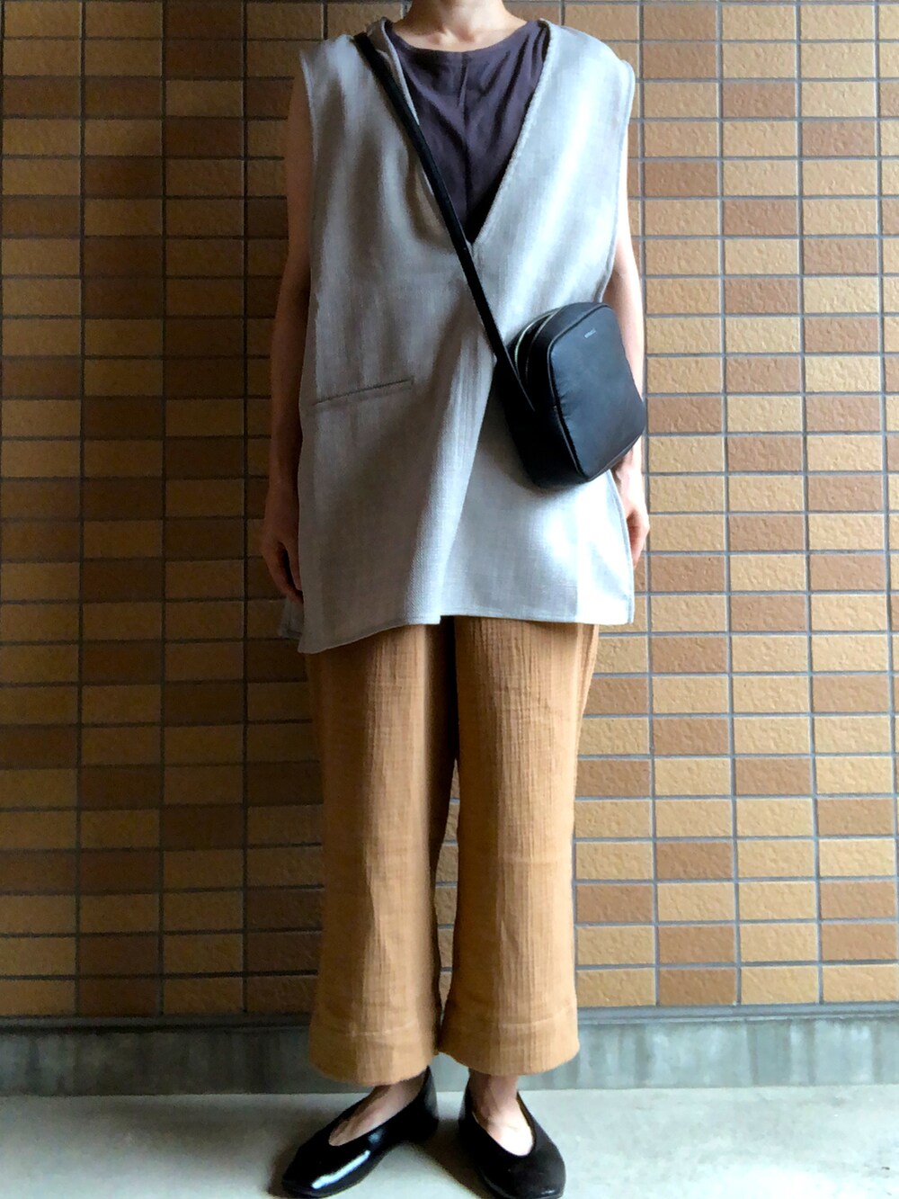 グレー系のベストを着用したレディースの夏コーディネートの2枚目の写真