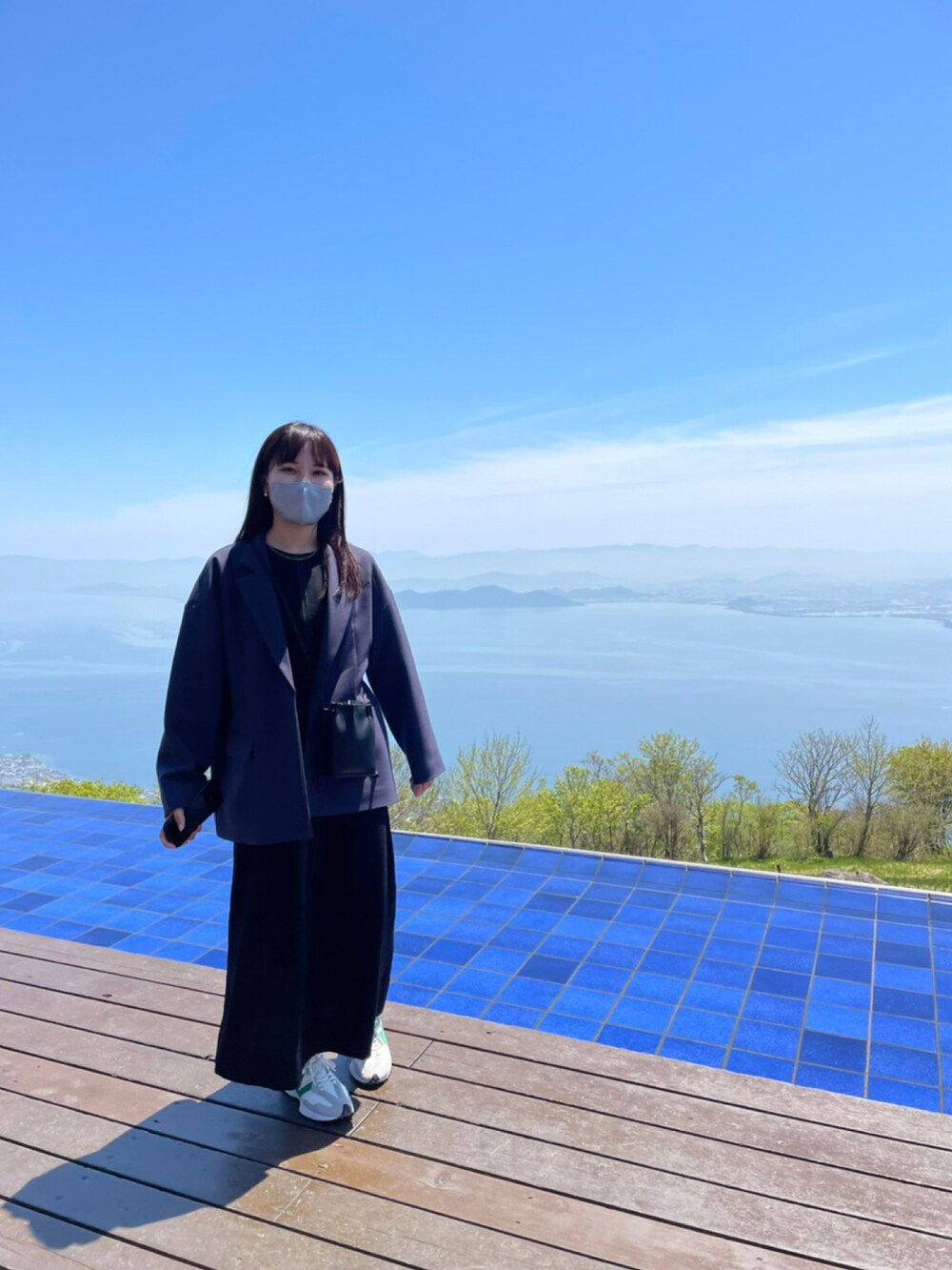 ブラック系のワンピース、ブラック系のテーラードジャケットを着用したレディースの春コーディネートの2枚目の写真