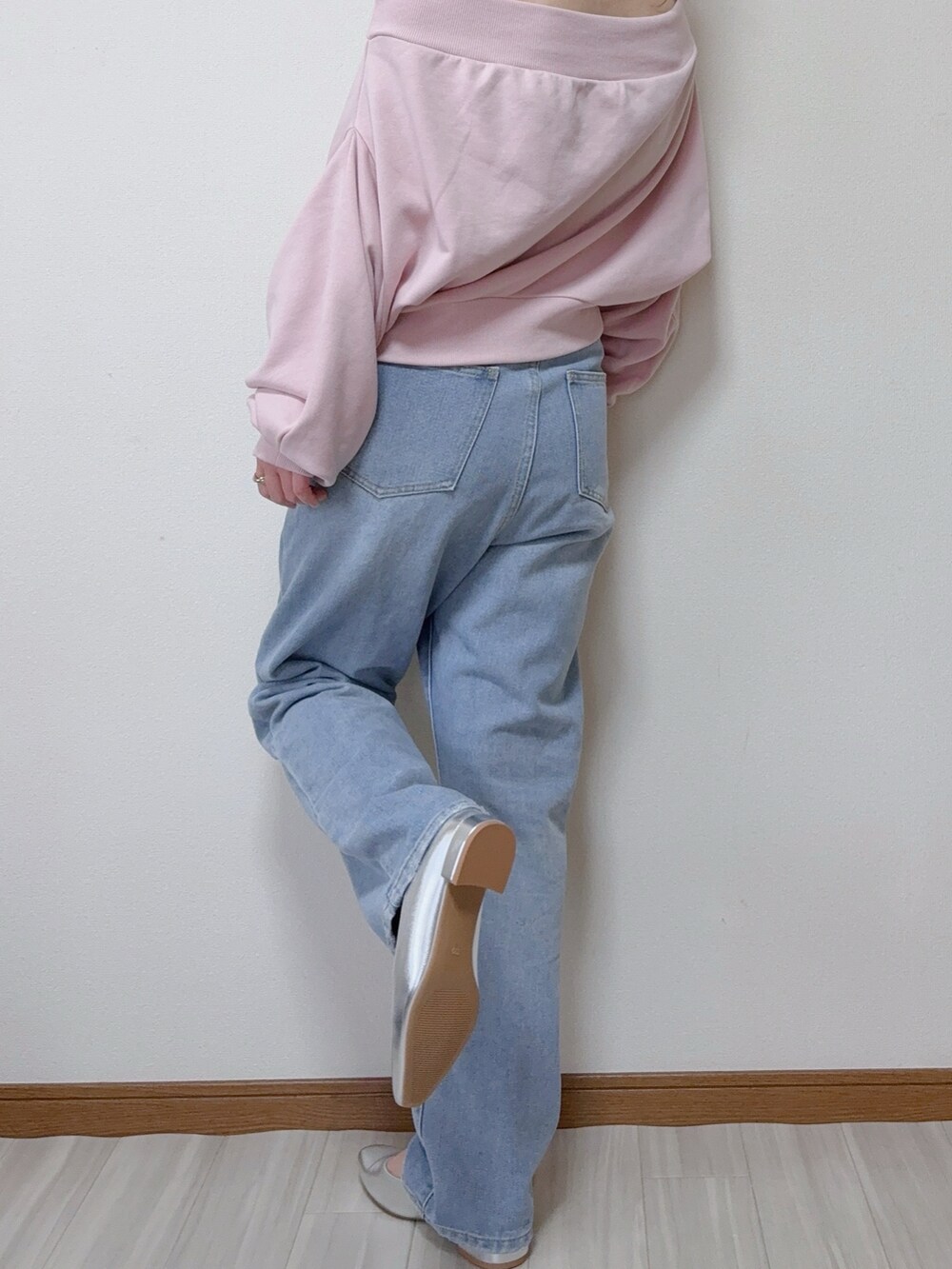 ピンク系のスウェット、ブルー系のデニムパンツ、シルバー系のパンプスを着用したレディースの春コーディネートの2枚目の写真