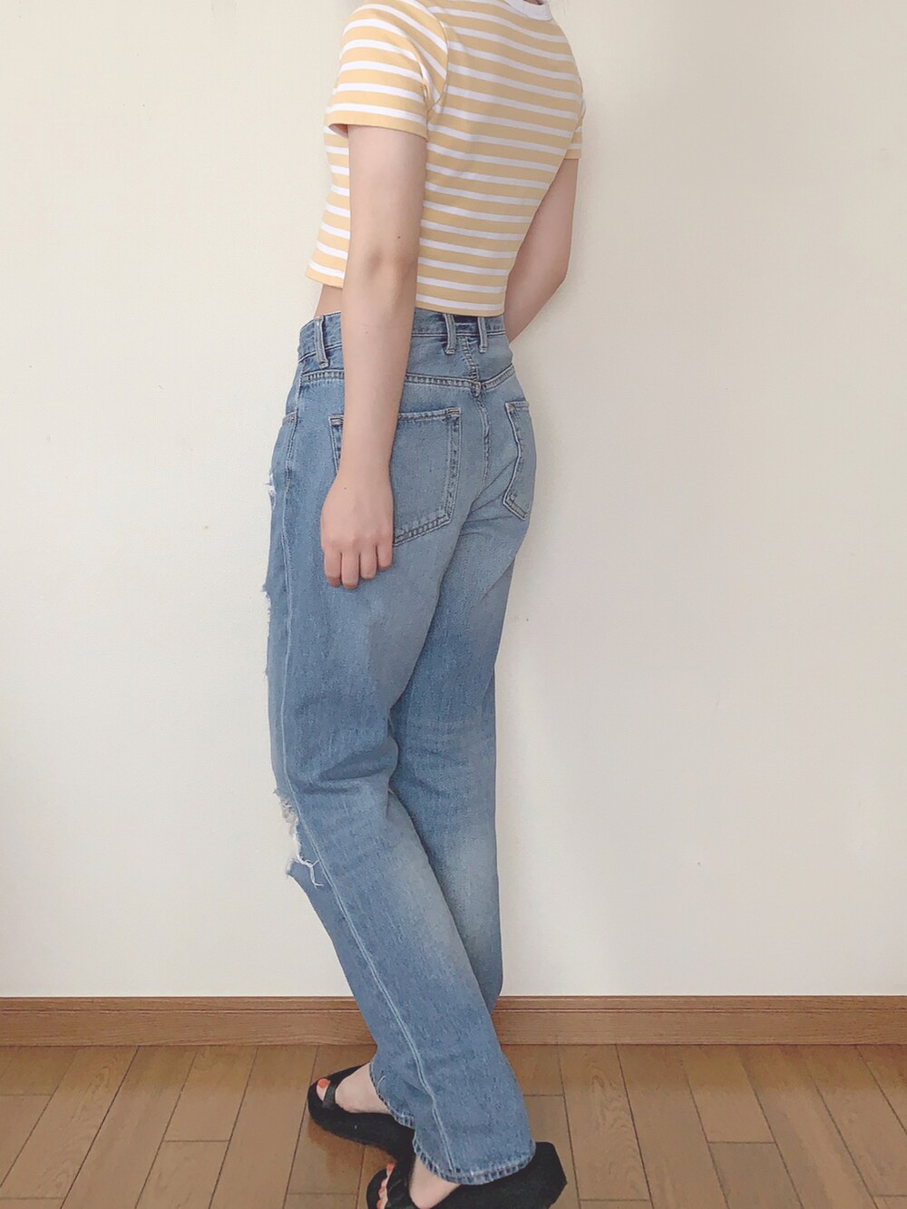 イエロー系のトップス、ブルー系のパンツ、ブラック系のサンダルを着用したレディースの夏コーディネートの2枚目の写真