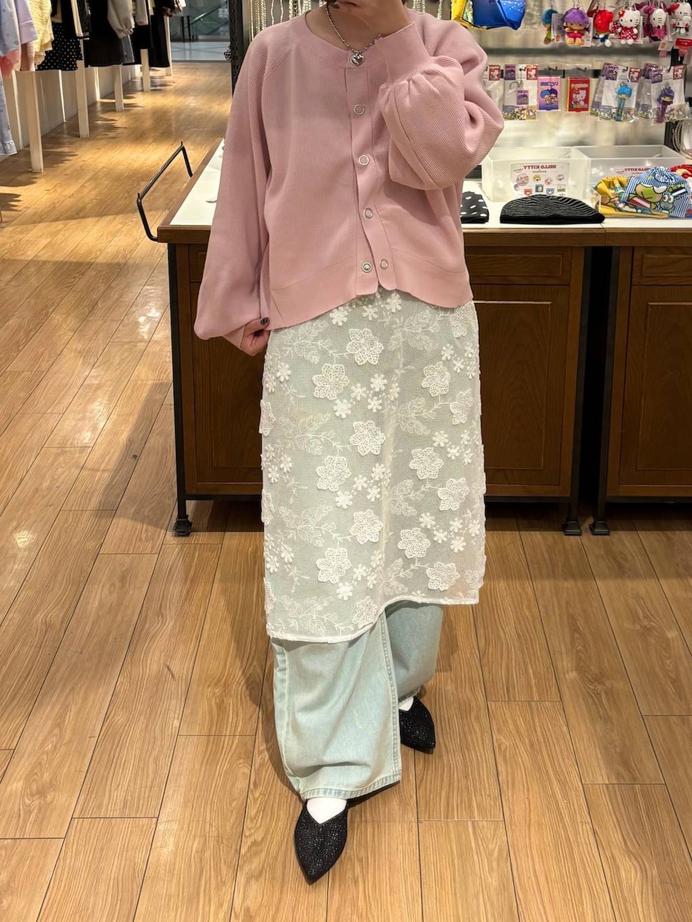 ブルー系のデニムパンツ、ブラック系のパンプス、ホワイト系のスカートを着用したレディースの冬コーディネートの3枚目の写真