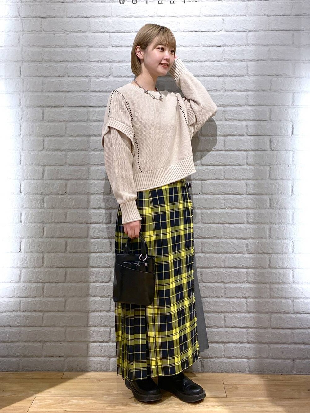 ホワイト系のTシャツ/カットソー、ブラック系のブーツ、ブラック系のショルダーバッグを着用したレディースの冬コーディネートの2枚目の写真