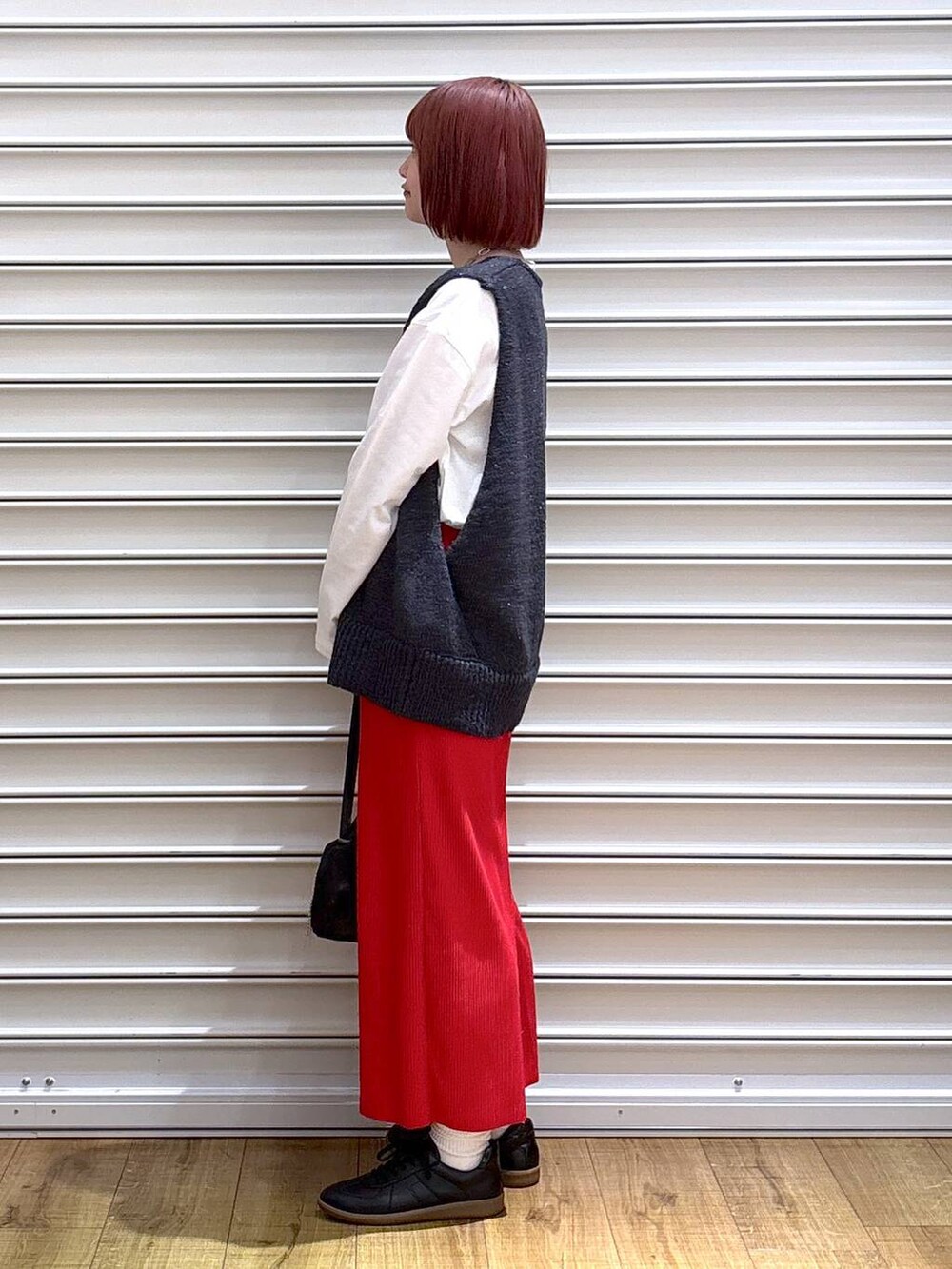 レッド系のスカート、ホワイト系のTシャツ/カットソー、シルバー系のトートバッグを着用したレディースの春コーディネートの3枚目の写真