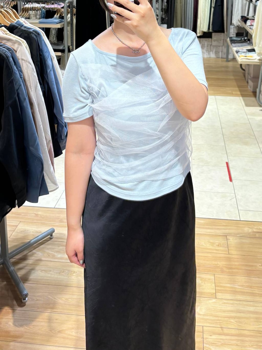 ブルー系のTシャツ/カットソー、ブラック系のスカート、ブラック系のサンダルを着用したレディースの夏コーディネートの2枚目の写真