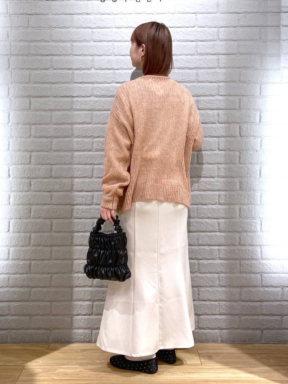 ベージュ系のTシャツ/カットソー、ホワイト系のスカート、ピンク系のニット/セーターを着用したレディースの冬コーディネートの3枚目の写真