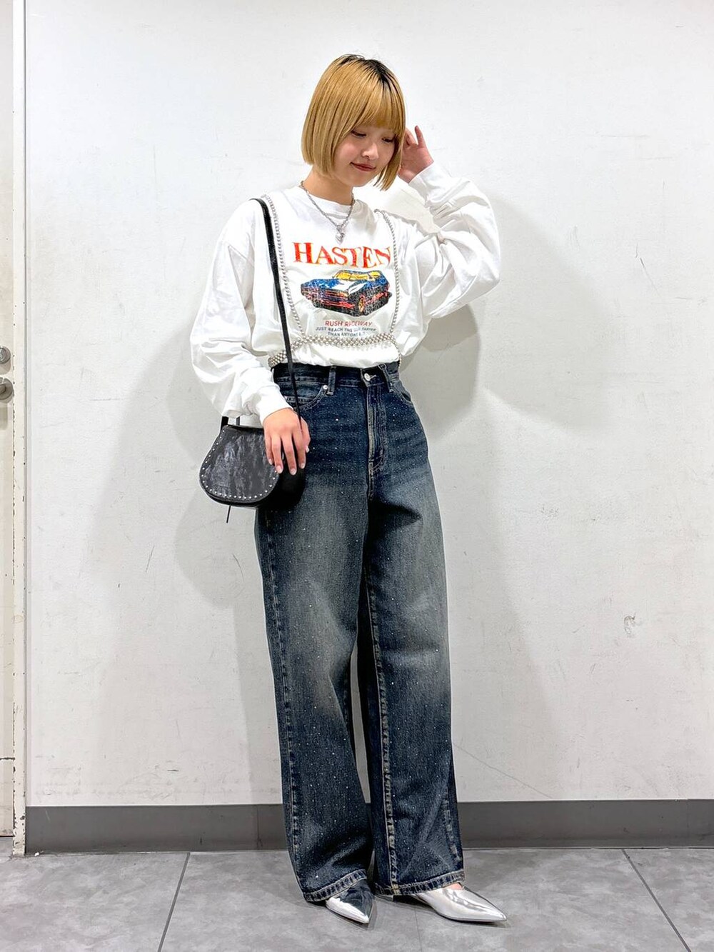 シルバー系のパンプス、ホワイト系のTシャツ/カットソー、ブルー系のデニムパンツを着用したレディースの秋コーディネートの2枚目の写真