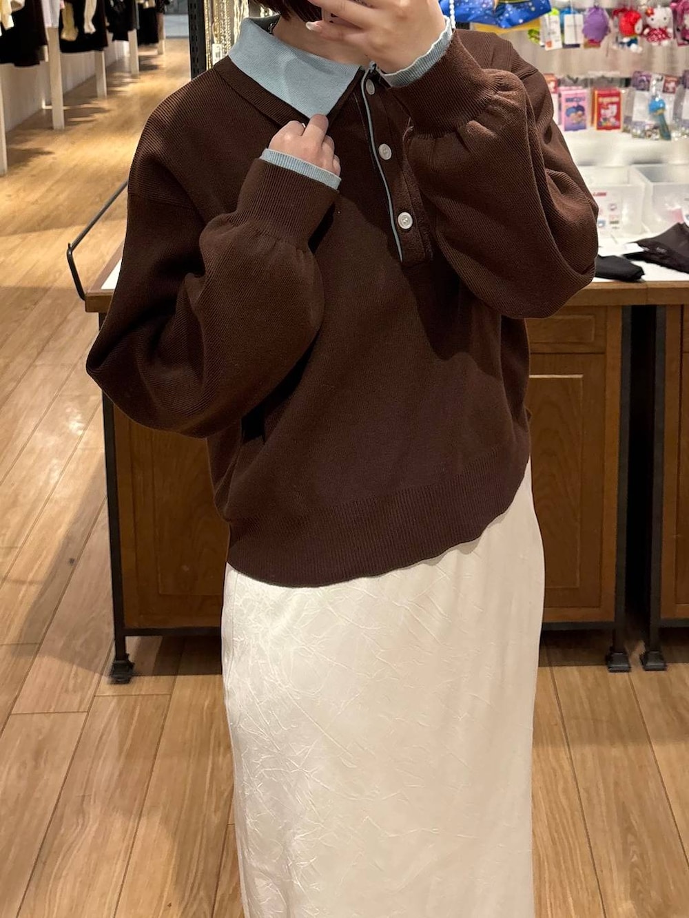 ホワイト系のスカート、ブラック系のローファー、ブラウン系のニット/セーターを着用したレディースの冬コーディネートの2枚目の写真