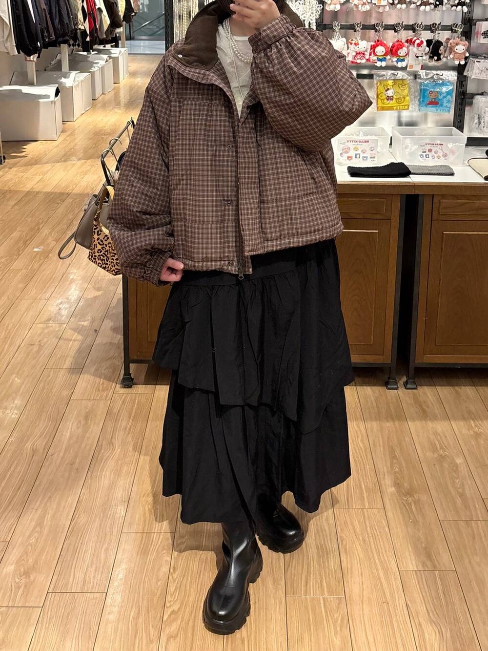 ブラック系のブーツ、ブラック系のスカート、ブラウン系のブルゾンを着用したレディースの冬コーディネートの3枚目の写真