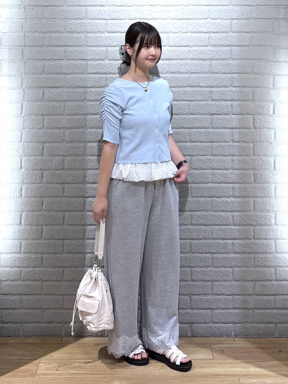 ホワイト系のサンダル、ブルー系のTシャツ/カットソー、グレー系のスウェットパンツを着用したレディースの夏コーディネートの2枚目の写真