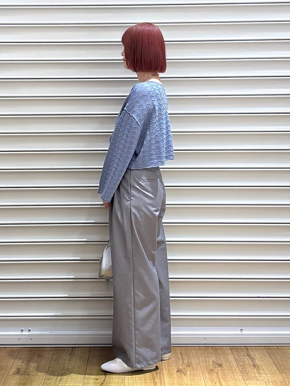 シルバー系のトートバッグ、ゴールド系のタンクトップ、ホワイト系のスニーカーを着用したレディースの春コーディネートの3枚目の写真