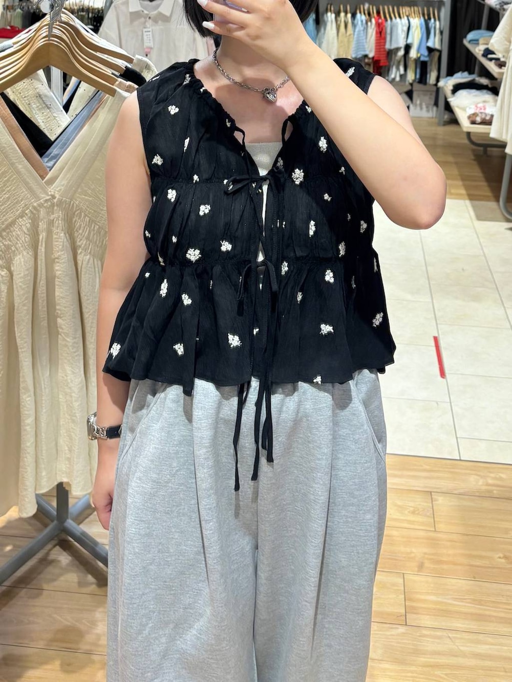 グレー系のスウェットパンツ、シルバー系のタンクトップ、ブラック系のサンダルを着用したレディースの夏コーディネートの2枚目の写真