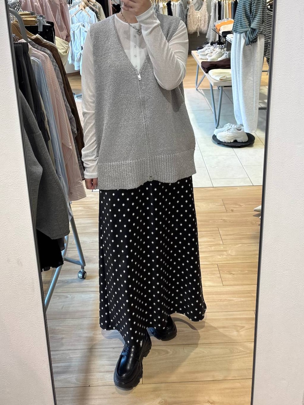 ブラック系のスカート、ブラック系のローファー、ホワイト系のTシャツ/カットソーを着用したレディースの春コーディネートの3枚目の写真