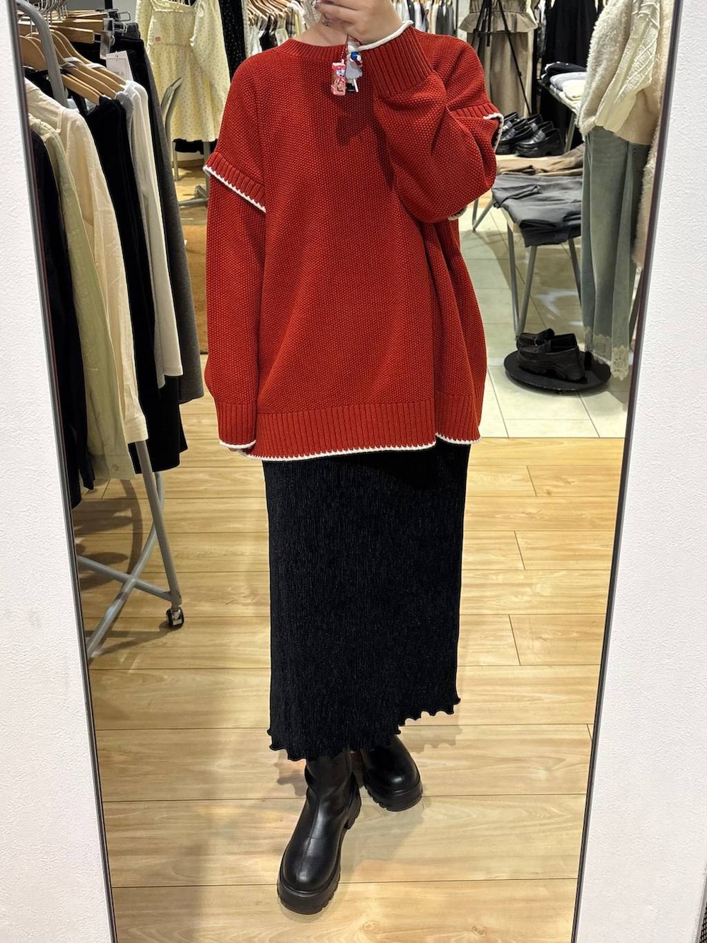 ブラック系のスカート、レッド系のニット/セーターを着用したレディースの秋コーディネートの3枚目の写真
