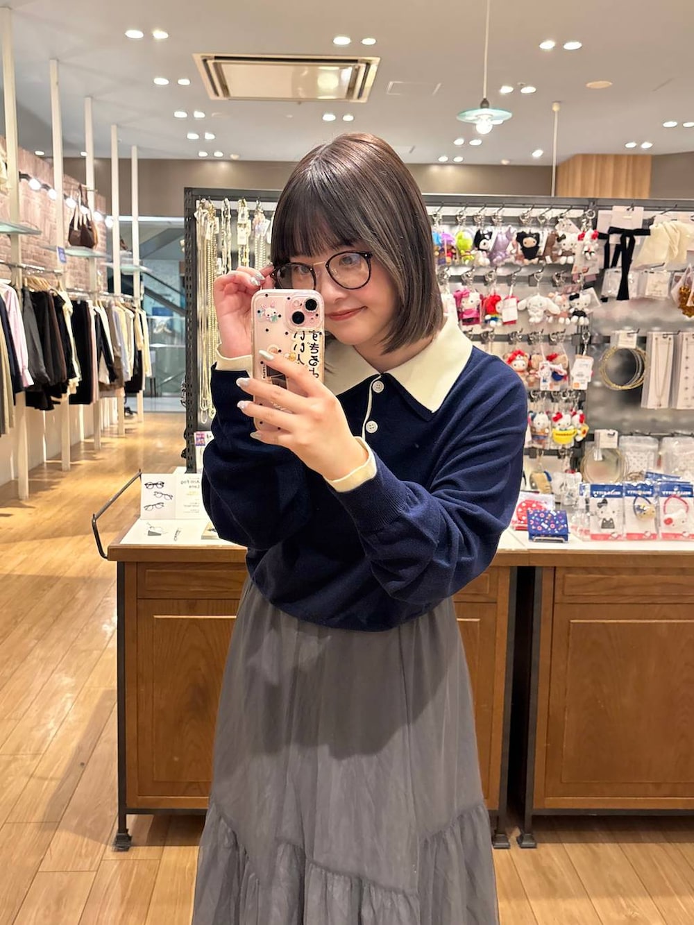 ブラック系のサンダル、グレー系のスカート、ブルー系のニット/セーターを着用したレディースの春コーディネートの2枚目の写真