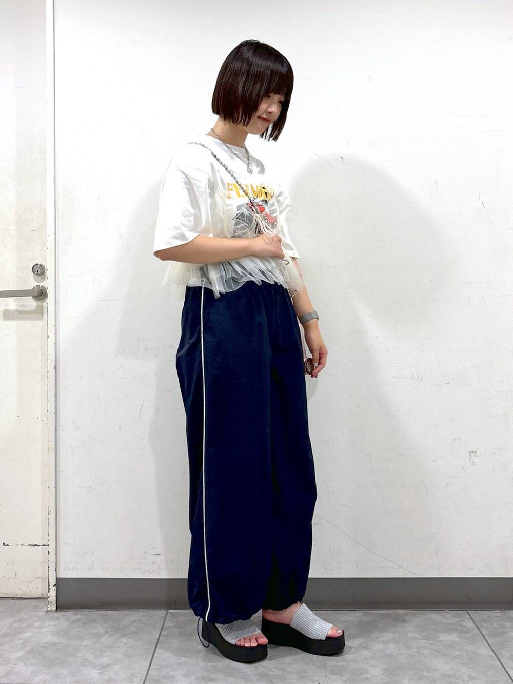 シルバー系のサンダル、ホワイト系のベスト、ホワイト系のTシャツ/カットソーを着用したレディースの夏コーディネートの2枚目の写真