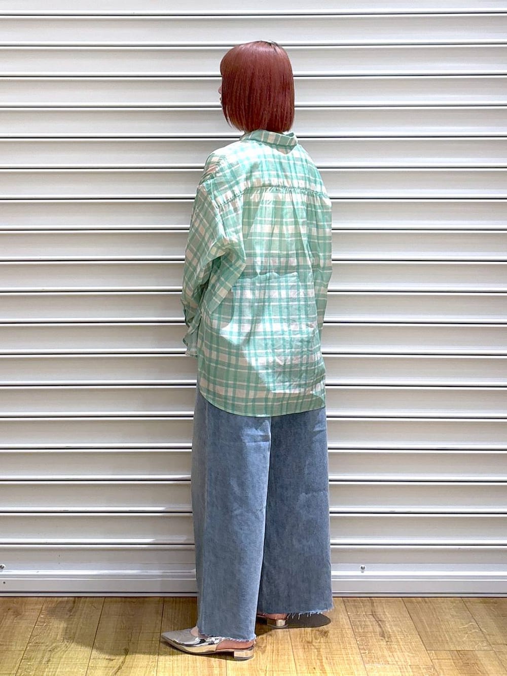 グリーン系のシャツ/ブラウス、シルバー系のトートバッグ、ホワイト系のタンクトップを着用したレディースの春コーディネートの3枚目の写真