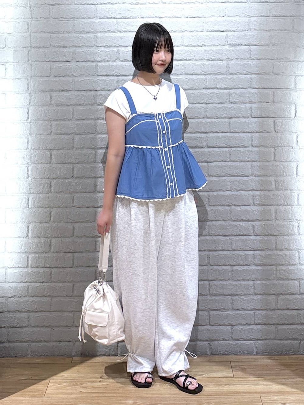 ホワイト系のTシャツ/カットソー、グレー系のスウェットパンツ、ブラック系のサンダルを着用したレディースの夏コーディネートの2枚目の写真