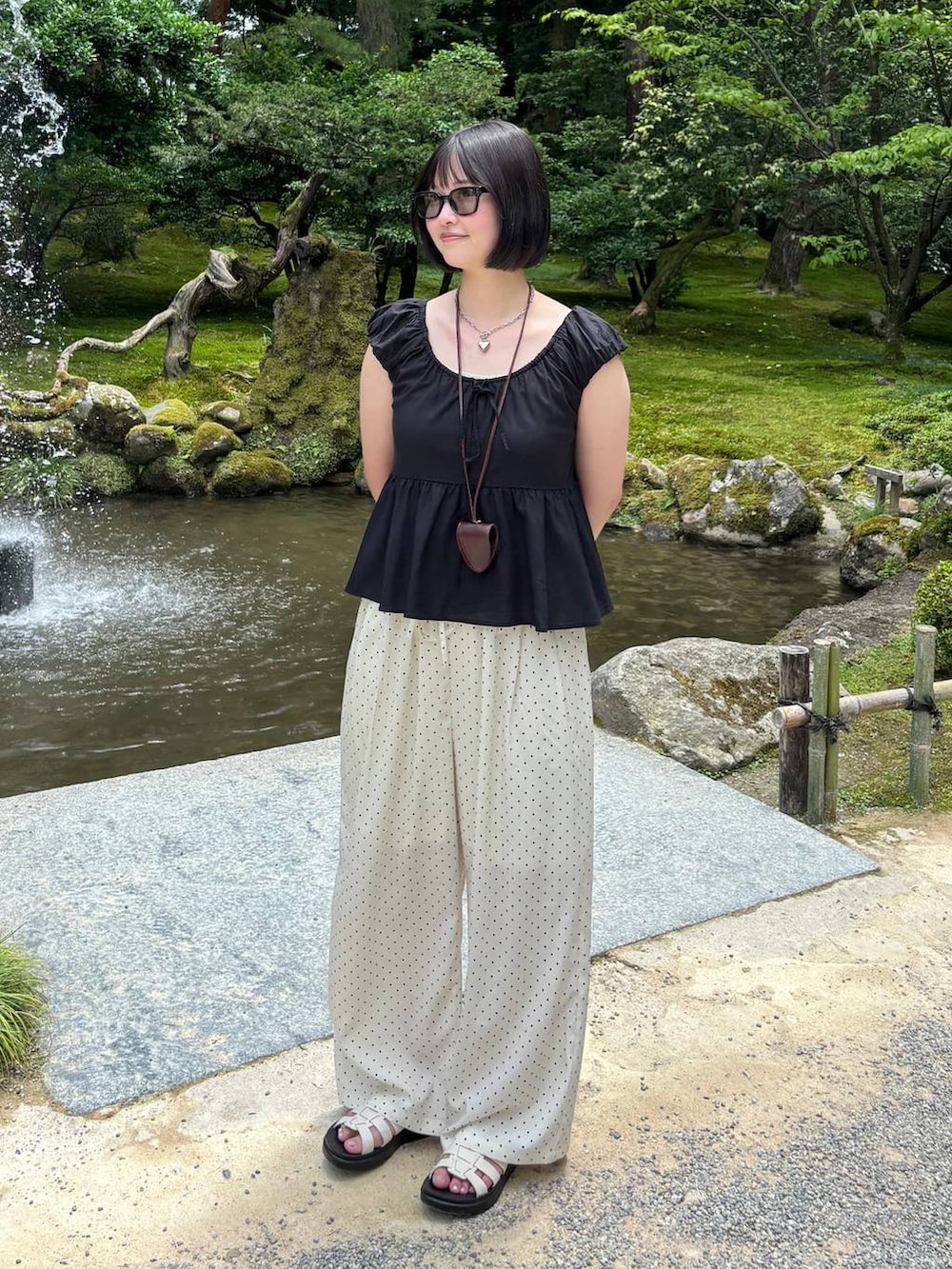 ホワイト系のサンダル、ホワイト系のその他パンツ、ブラウン系のその他小物を着用したレディースの夏コーディネートの3枚目の写真
