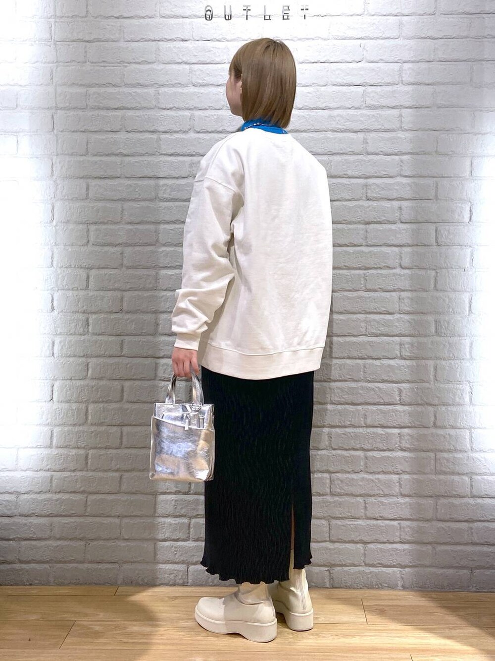 ホワイト系のスウェット、ブルー系のニット/セーター、ホワイト系のブーツを着用したレディースの冬コーディネートの3枚目の写真