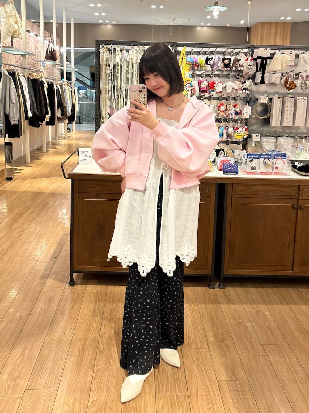 シルバー系のタンクトップ、ピンク系のパーカー、ホワイト系のパンプスを着用したレディースの春コーディネートの3枚目の写真