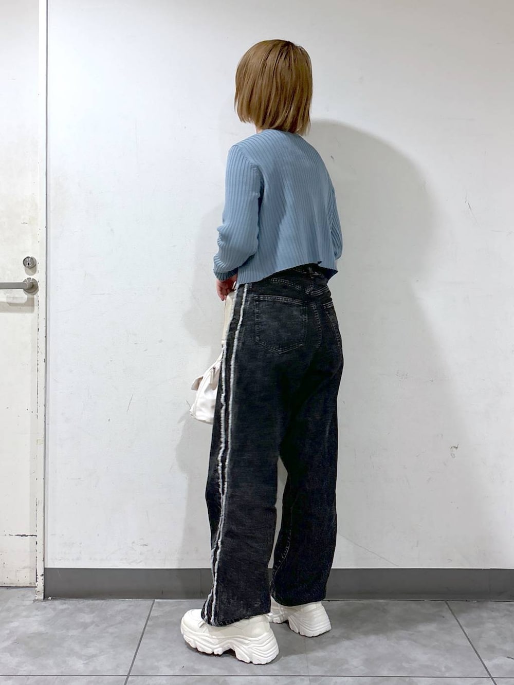 ブルー系のカーディガン/ボレロ、ブラック系のデニムパンツ、ホワイト系のスニーカーを着用したレディースの秋コーディネートの2枚目の写真