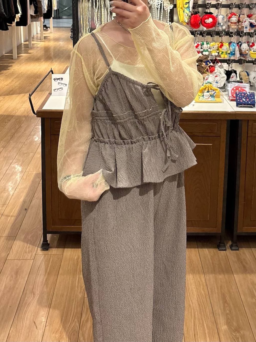 ブラウン系のスニーカー、イエロー系のTシャツ/カットソー、ブラウン系のサロペット/オーバーオールを着用したレディースの春コーディネートの3枚目の写真