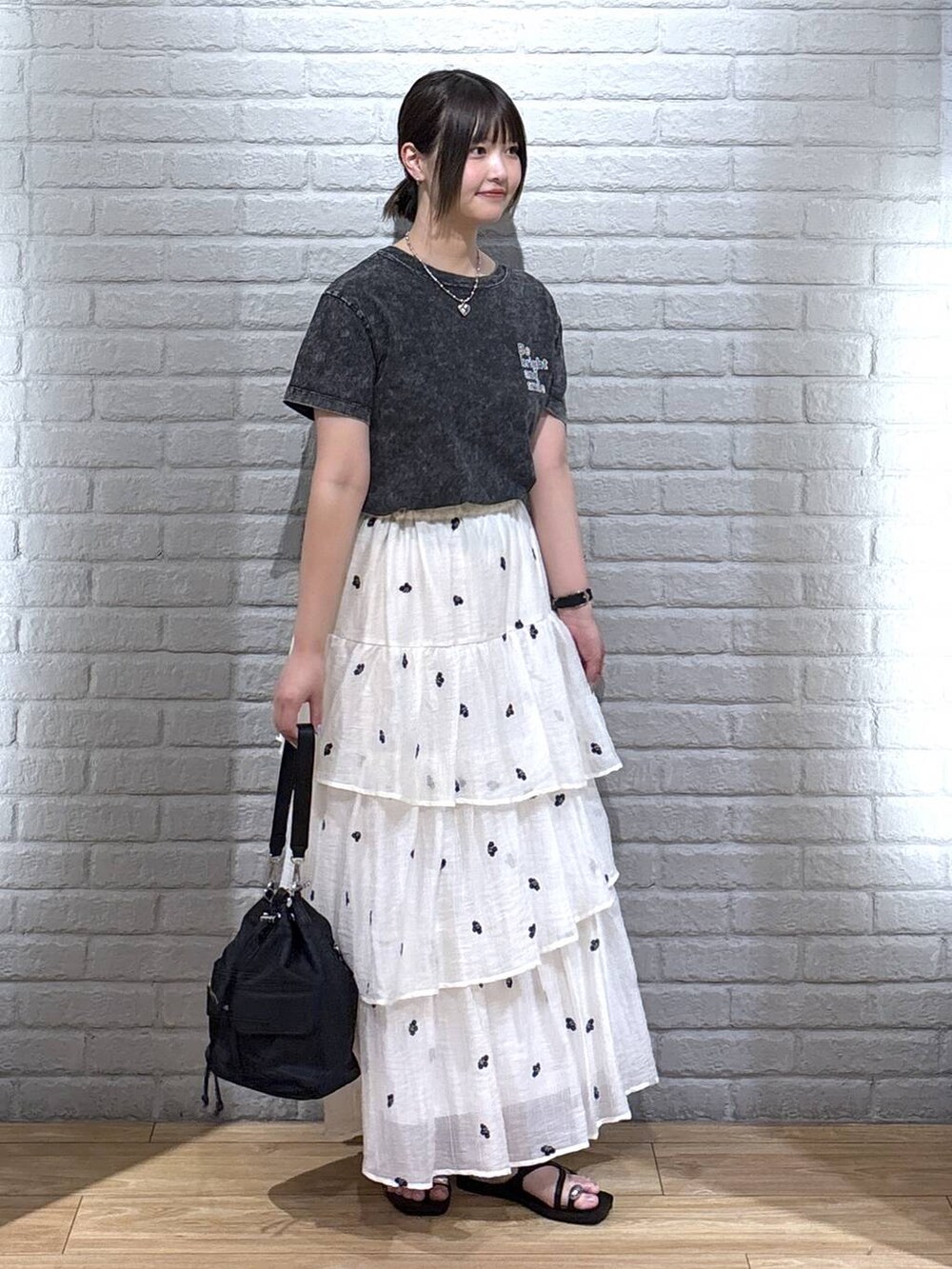 ブラック系のサンダル、ホワイト系のスカート、ブラック系のショルダーバッグを着用したレディースの夏コーディネートの3枚目の写真