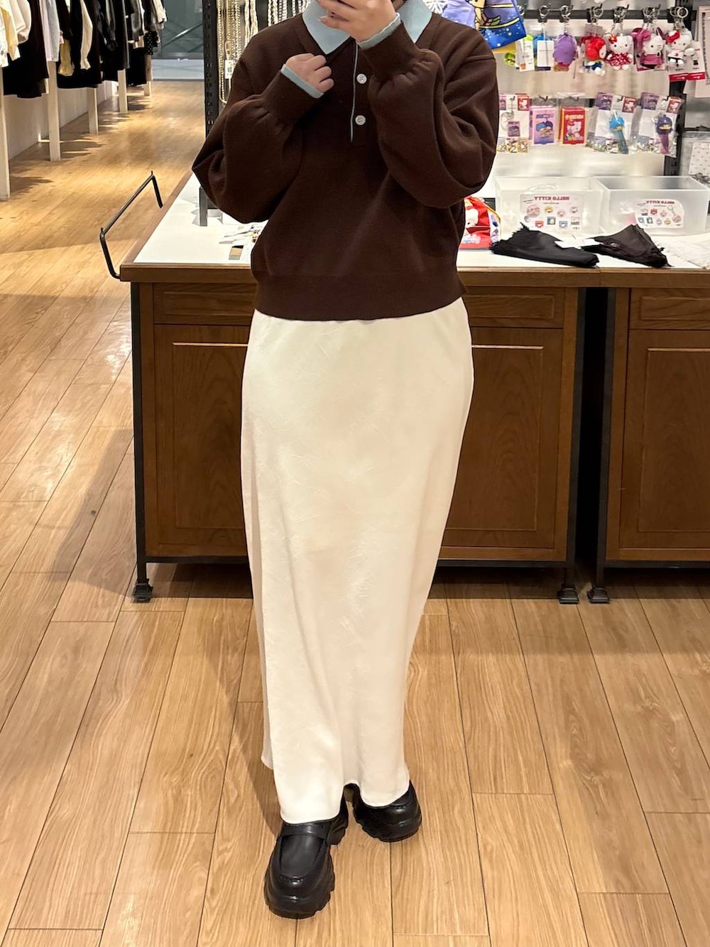 ホワイト系のスカート、ブラック系のローファー、ブラウン系のニット/セーターを着用したレディースの冬コーディネートの3枚目の写真