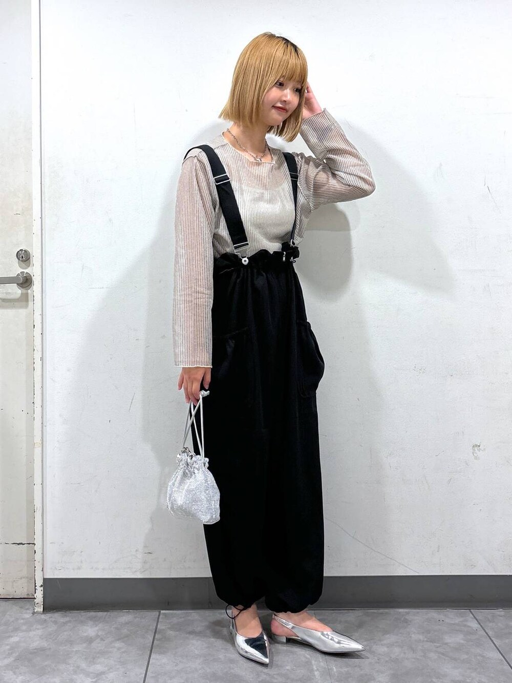 シルバー系のパンプス、ホワイト系のTシャツ/カットソー、ブラック系のワンピースを着用したレディースの夏コーディネートの2枚目の写真