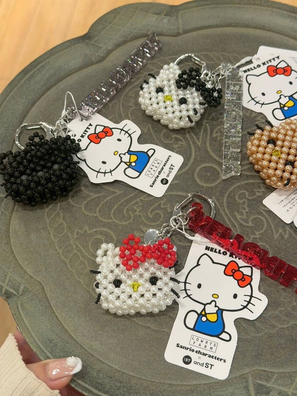 レッド系のキーホルダー、ゴールド系のキーホルダー、ブラック系のキーホルダーを着用したレディースの冬コーディネートの2枚目の写真