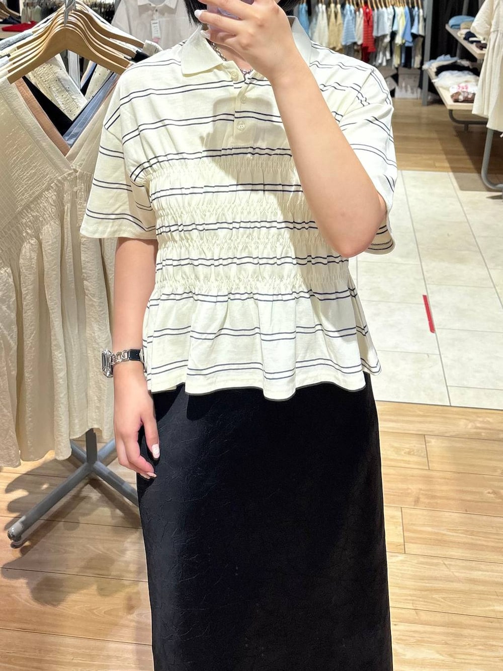ブラック系のスカート、ブラウン系のサンダル、ホワイト系のTシャツ/カットソーを着用したレディースの夏コーディネートの2枚目の写真
