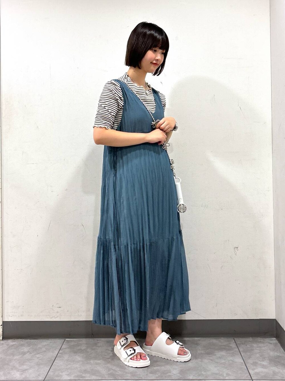 ブルー系のワンピース、ホワイト系のTシャツ/カットソー、ホワイト系のサンダルを着用したレディースの夏コーディネートの2枚目の写真