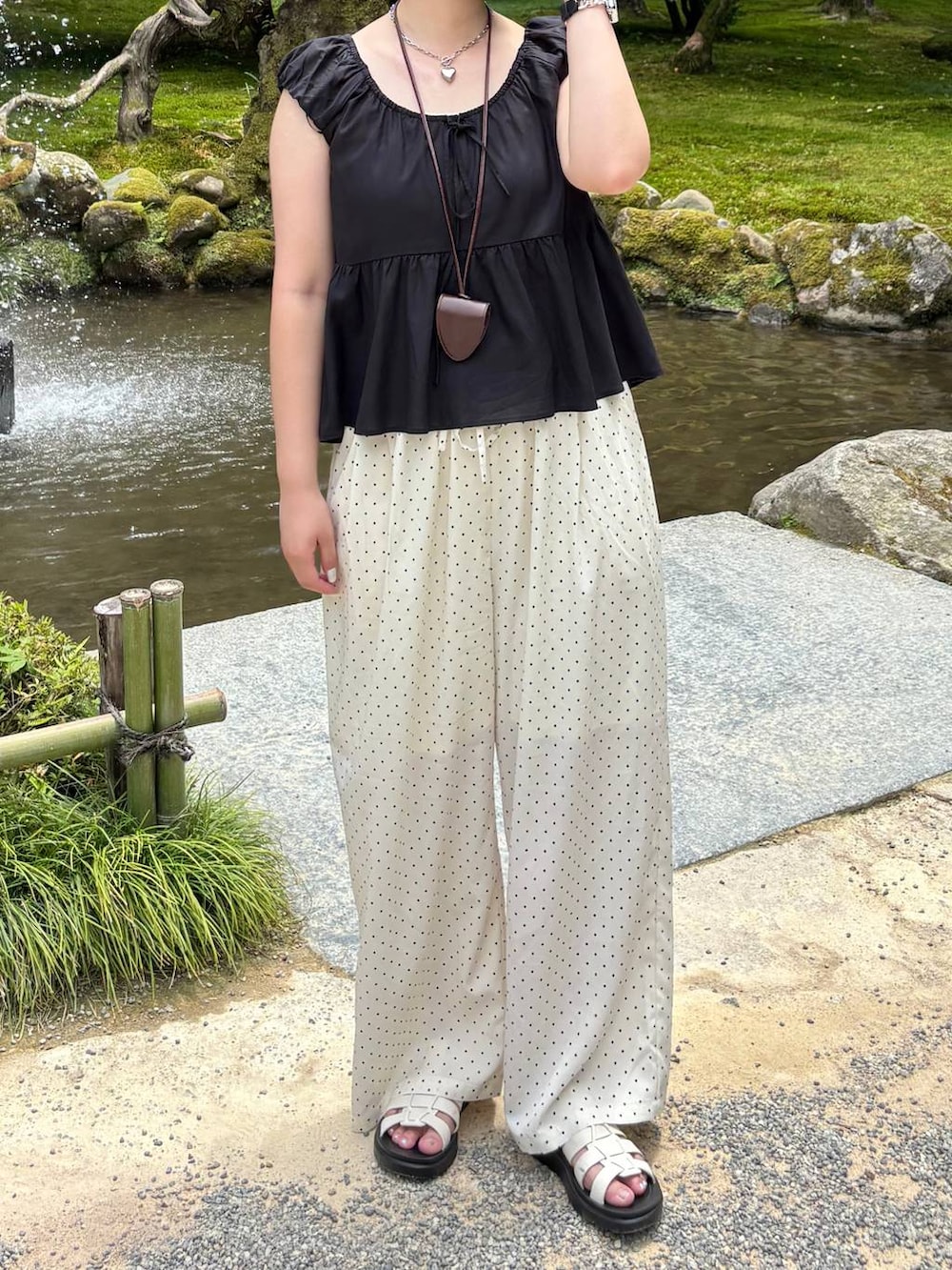ホワイト系のサンダル、ホワイト系のその他パンツ、ブラウン系のその他小物を着用したレディースの夏コーディネートの2枚目の写真