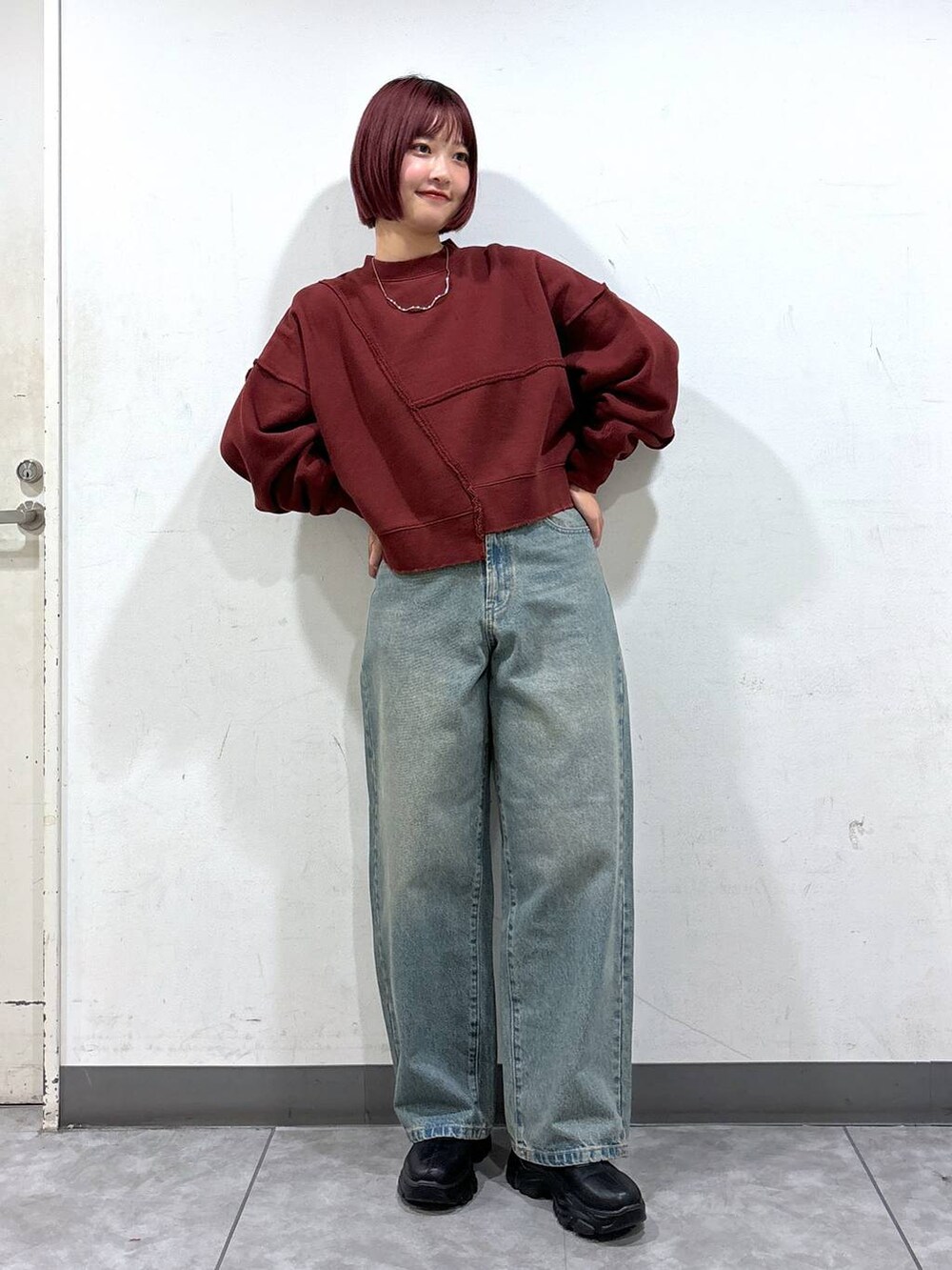 ブルー系のデニムパンツ、ブラック系のブーツ、ブラック系のショルダーバッグを着用したレディースの秋コーディネートの5枚目の写真