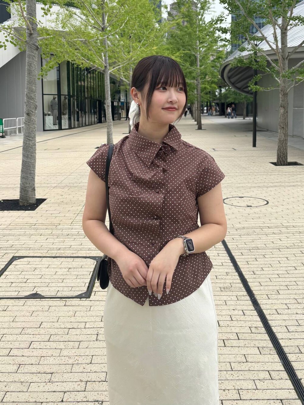 ホワイト系のスカート、ブラック系のサンダル、ブラック系のボディバッグ/ウエストポーチを着用したレディースの夏コーディネートの2枚目の写真